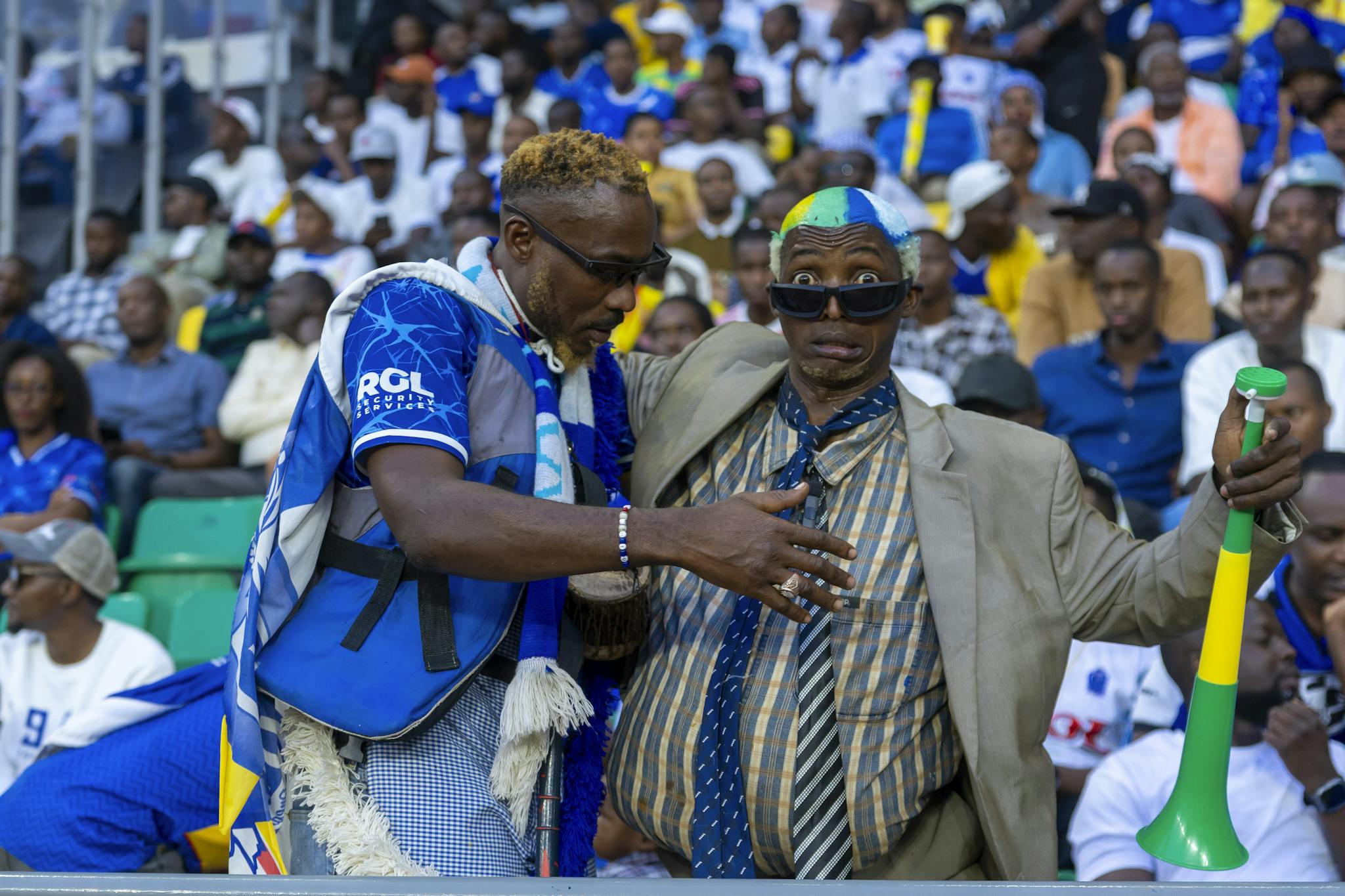 Energetic sports fans in colorful attire passionately cheering at a lively stadium event.